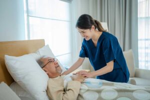 A senior arranging family photos and keepsakes on a bedside table in a cozy, personalized assisted living room.